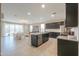 Open concept kitchen with stainless steel appliances, center island, flowing into the bright living area at 37903 W San Clemente St, Maricopa, AZ 85138