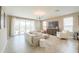 Bright living room with neutral decor, tile flooring, and sliding glass doors to the backyard at 37903 W San Clemente St, Maricopa, AZ 85138