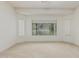 A large bedroom features a neutral carpet, large windows and white paint at 42310 W Fountainhead St, Maricopa, AZ 85138