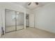 A carpeted bedroom with a fan features mirrored closet doors and a window at 42310 W Fountainhead St, Maricopa, AZ 85138