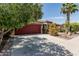 Exterior view of home showcasing the garage, desert landscaping, and mature trees at 42310 W Fountainhead St, Maricopa, AZ 85138