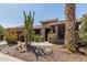 Desert home with landscaped yard, featuring cacti, boulders, desert plants, and mature palm tree at 42310 W Fountainhead St, Maricopa, AZ 85138