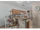 This kitchen features wood cabinets, granite countertops, tile floors and a bar with brick accents at 42310 W Fountainhead St, Maricopa, AZ 85138