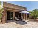 Covered patio with lounge chairs, a table and a sun umbrella at 42310 W Fountainhead St, Maricopa, AZ 85138