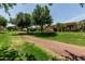 Grassy yard, mature trees and bushes with path at 42310 W Fountainhead St, Maricopa, AZ 85138