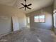 Bright room with a ceiling fan, and door leading to another room at 43213 W Cowpath Rd, Maricopa, AZ 85138