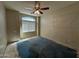 This bedroom features a ceiling fan and natural light from a window with coverings at 43213 W Cowpath Rd, Maricopa, AZ 85138