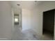 Bright hallway with crisp white walls and concrete floors leads to a room with plenty of natural light at 47706 W Moeller Rd, Maricopa, AZ 85139