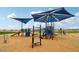 Community playground area featuring a variety of slides, climbing structures, and sun shades at 47706 W Moeller Rd, Maricopa, AZ 85139