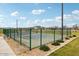 Outdoor tennis court with green fencing surrounded by desert landscaping under a clear blue sky at 47706 W Moeller Rd, Maricopa, AZ 85139