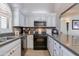 Well-lit kitchen featuring white cabinets, stainless steel appliances, and elegant granite countertops at 6138 N 28Th St, Phoenix, AZ 85016