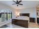 Serene bedroom with a large window, plantation shutters, ceiling fan, and a dark wood bed frame at 6138 N 28Th St, Phoenix, AZ 85016
