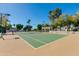 Outdoor tennis court with green surface, set against a clear blue sky and mature landscaping at 6138 N 28Th St, Phoenix, AZ 85016