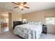 Bedroom with a ceiling fan, windows, dresser, and carpeted floors at 7169 S Dodane Ct, Gilbert, AZ 85298