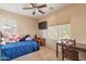 Comfortable bedroom with a bed, wooden desk, and a large window, perfect for relaxation and study at 7169 S Dodane Ct, Gilbert, AZ 85298