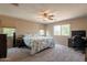 Spacious carpeted bedroom with a ceiling fan, large windows, a computer desk, and neutral paint at 7169 S Dodane Ct, Gilbert, AZ 85298