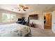 Carpeted bedroom featuring a ceiling fan, desk, TV, and neutral colored walls at 7169 S Dodane Ct, Gilbert, AZ 85298