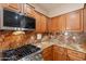 The kitchen boasts granite countertops, wooden cabinets, stainless steel stove and microwave oven at 7169 S Dodane Ct, Gilbert, AZ 85298