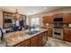 Kitchen island with granite countertop, stainless steel appliances, and adjacent dining area at 7169 S Dodane Ct, Gilbert, AZ 85298