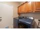 This laundry room features a washer and dryer, storage cabinets, and a door to the outside at 7169 S Dodane Ct, Gilbert, AZ 85298