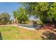Enjoy this outdoor space with a pool, mature trees, lounge chairs, and an iron fence at 7169 S Dodane Ct, Gilbert, AZ 85298