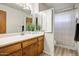 Well lit bathroom boasts a wide mirror, faux plant decor, and a shower-tub combination at 7424 E Cambridge Ave, Scottsdale, AZ 85257