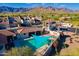 Aerial view of desert property with a swimming pool, shade sail, mountain views, and beautiful landscaping at 8950 E Greenview Dr, Gold Canyon, AZ 85118