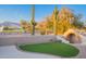 Expansive turf lawn with brick patio, outdoor kitchen area, saguaro cacti, and mountain views at 8950 E Greenview Dr, Gold Canyon, AZ 85118