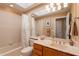 Bright bathroom featuring a tub with shower, skylight, and wood cabinets at 8950 E Greenview Dr, Gold Canyon, AZ 85118