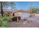 Front exterior with desert landscaping, flowering bushes, rock accents, and two-car garage at 8950 E Greenview Dr, Gold Canyon, AZ 85118