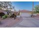 Single-story home featuring a charming front yard with beautiful desert landscaping and two-car garage at 8950 E Greenview Dr, Gold Canyon, AZ 85118