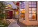 Beautiful exterior view with arched windows, red door, and lush greenery leading to the front door at 8950 E Greenview Dr, Gold Canyon, AZ 85118