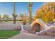 Desert property patio featuring desert landscape, brick pavers, and an outdoor kitchen with a bench at 8950 E Greenview Dr, Gold Canyon, AZ 85118