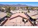 An aerial view shows mountain views behind homes with gravel yards and clay tile roofs at 9175 E Rainier Dr, Gold Canyon, AZ 85118