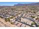 Expansive aerial view of a neighborhood showcasing well-kept homes, desert landscaping, and mountain views in the distance at 9175 E Rainier Dr, Gold Canyon, AZ 85118