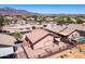 An aerial view shows a home in a neighborhood with gravel yards and beautiful mountain views at 9175 E Rainier Dr, Gold Canyon, AZ 85118