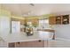 Well-lit kitchen boasts wood cabinetry, a functional island, and modern white appliances for cooking convenience at 9175 E Rainier Dr, Gold Canyon, AZ 85118
