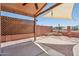 A quaint backyard patio features a brick privacy wall, canvas shade, and desert landscaping at 9175 E Rainier Dr, Gold Canyon, AZ 85118