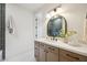 Bright bathroom with a wooden vanity, marble countertop, and decorative arched mirror at 9322 E Hidden Green Dr, Scottsdale, AZ 85262