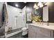 Elegant bathroom featuring modern lighting, a stylish vanity, a glass-enclosed shower, and chic black-and-white accents at 9322 E Hidden Green Dr, Scottsdale, AZ 85262