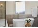 Bright bathroom features a shower, a freestanding tub, and a frosted window at 9322 E Hidden Green Dr, Scottsdale, AZ 85262