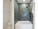 Stylish bathroom with a tiled shower featuring a rainfall showerhead and a built-in niche at 9322 E Hidden Green Dr, Scottsdale, AZ 85262