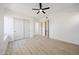 Spacious bedroom with light hardwood floors, a ceiling fan, closet doors, and neutral tones creating a modern, minimalist appeal at 9322 E Hidden Green Dr, Scottsdale, AZ 85262