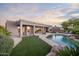 Stunning backyard showcasing a modern home design with a pool, patio, and manicured lawn at 9322 E Hidden Green Dr, Scottsdale, AZ 85262
