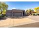 Well maintained home featuring a three-car garage, desert landscaping, and paved driveway at 9322 E Hidden Green Dr, Scottsdale, AZ 85262