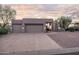 Well-maintained home exterior with a spacious driveway, three-car garage, and desert-friendly landscaping at 9322 E Hidden Green Dr, Scottsdale, AZ 85262