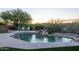 Tranquil pool area with lush landscaping, a rock waterfall feature, and relaxing lounge chairs at 9322 E Hidden Green Dr, Scottsdale, AZ 85262