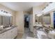 Well-lit main bathroom features double sinks, framed mirrors, and a walk-in closet with storage space at 9745 N 95Th St # 227, Scottsdale, AZ 85258