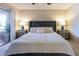 Bright main bedroom with a tufted headboard, bedside tables with lamps, and sliding glass doors at 9745 N 95Th St # 227, Scottsdale, AZ 85258