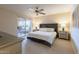 Bright main bedroom features a tufted headboard, ceiling fan, and sliding glass doors to a patio at 9745 N 95Th St # 227, Scottsdale, AZ 85258